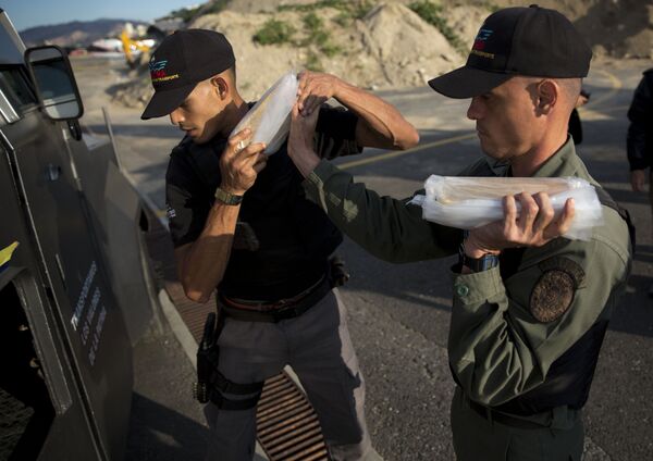 Members of a military agency that transports valuables put gold bars into an armored vehicle to be taken to Venezuela's Central Bank, at the Carlota military airport in Caracas, Venezuela, Thursday, March 1, 2018 - Sputnik International
