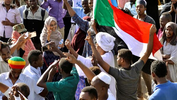 Sudanese demonstrators celebrate after Defence Minister Awad Ibn Auf stepped down as head of the country's transitional ruling military council, as protesters demanded quicker political change, near the Defence Ministry in Khartoum, Sudan April 13, 2019 - Sputnik International