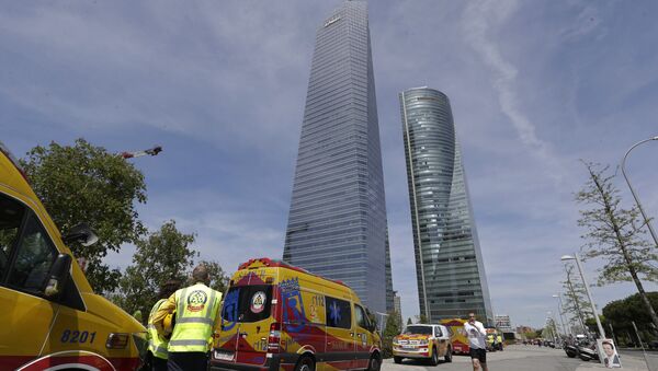 Ambulances wait outside the Torrespacio skyscraper, right, as a jogger runs by in Madrid, Spain, Tuesday, April 16, 2019, after the 57-storey office tower in Madrid's business district that houses several foreign embassies was evacuated due to an unspecified security threat - Sputnik International