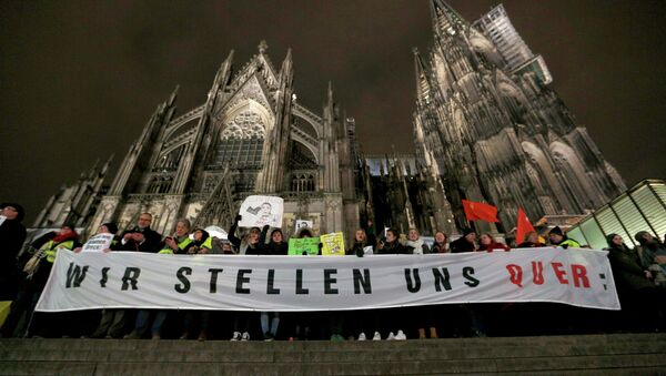 Protestors against KOGIDA stand with banners in front of the Cologne Cathedral during a KOGIDA demonstration rally in Cologne January 21, 2015 - Sputnik International