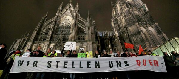 Protestors against KOGIDA stand with banners in front of the Cologne Cathedral during a KOGIDA demonstration rally in Cologne January 21, 2015 - Sputnik International