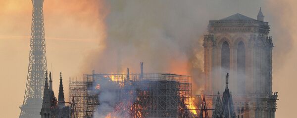 In this image made available on Tuesday April 16, 2019 flames and smoke rise from the blaze after the spire toppled over on Notre Dame cathedral in Paris, Monday, April 15, 2019 In this image made available on Tuesday April 16, 2019 flames and smoke rise from the blaze after the spire toppled over on Notre Dame cathedral in Paris, Monday, April 15, 2019 - Sputnik International
