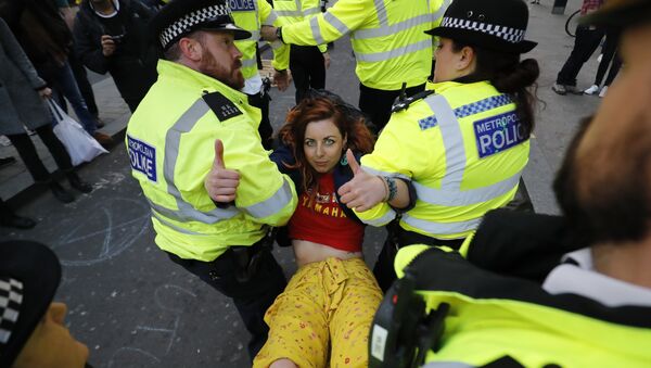 Police carry away a climate change activist protesting at Oxford Circus on the third day of an environmental protest by the Extinction Rebellion group, in London on April 17, 2019. - Sputnik International