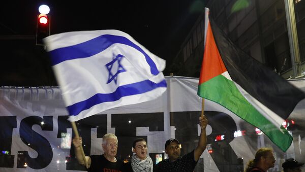 Arab Israelis and their supporters carry a Palestinian (R) and an Israeli flag during a demonstration to protest against the 'Jewish Nation-State Law' in the Israeli coastal city of Tel Aviv on August 11, 2018. - Sputnik International