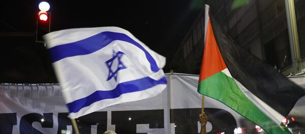 Arab Israelis and their supporters carry a Palestinian (R) and an Israeli flag during a demonstration to protest against the 'Jewish Nation-State Law' in the Israeli coastal city of Tel Aviv on August 11, 2018. Arab Israelis and their supporters carry a Palestinian (R) and an Israeli flag during a demonstration to protest against the 'Jewish Nation-State Law' in the Israeli coastal city of Tel Aviv on August 11, 2018. - Sputnik International