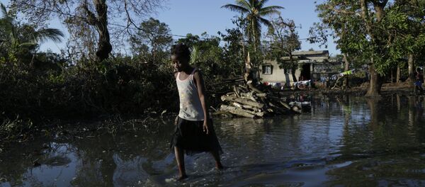 a young girl walks through flood waters near Beira, Mozambique, March 26, 2019, in one of the world's areas most vulnerable to global warming's rising waters - Sputnik International