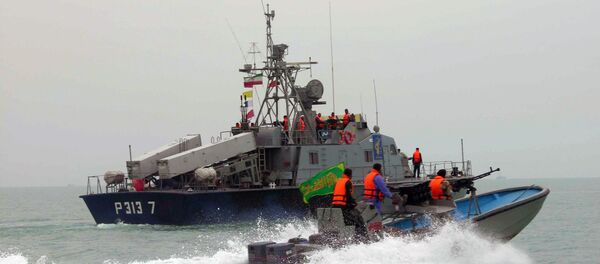 A picture released by the official Iranian News Agency shows members of Iran's elite Revolutionary Guard riding their boat along with an Iranian naval vessel during manoeuvers along the Gulf Sea and Sea of Oman, 03 April 2006 - Sputnik International