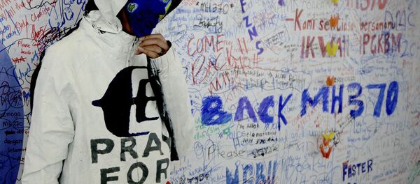 An unidentified woman wearing a mask depicting the flight of the missing Malaysia Airline, MH370, poses in front of the wall of hope at Kuala Lumpur International Airport in Sepang, Malaysia, Monday, March 17, 2014 An unidentified woman wearing a mask depicting the flight of the missing Malaysia Airline, MH370, poses in front of the wall of hope at Kuala Lumpur International Airport in Sepang, Malaysia, Monday, March 17, 2014 - Sputnik International