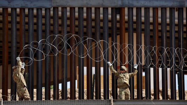 U.S. soldiers install concertina wire next to the border fence between Mexico and the United States, in El Paso, Texas, U.S., in this picture taken from Ciudad Juarez, Mexico, April 4, 2019 - Sputnik International