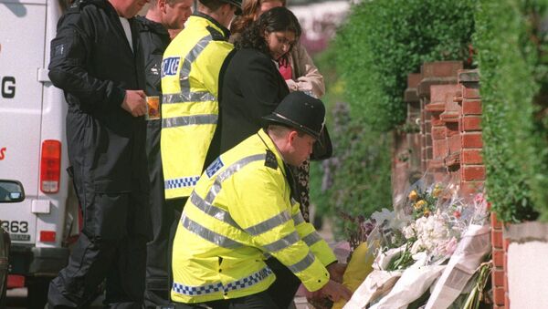 A police officer lays a floral tribute to murdered TV presenter Jill Dando at her home in London where she was murdered in April 1999 - Sputnik International