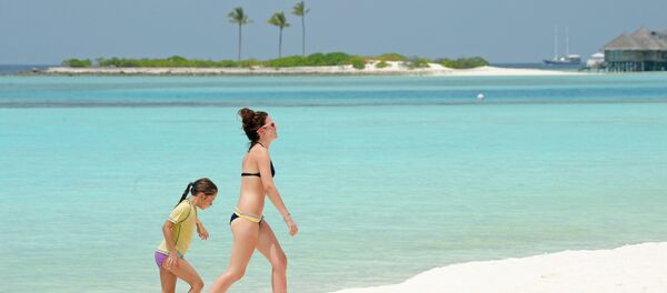 Unidentified foreign tourists walk along a beach of the Paradise Island Resort and Spa in the North Male' Atoll on February 14, 2012 Unidentified foreign tourists walk along a beach of the Paradise Island Resort and Spa in the North Male' Atoll on February 14, 2012 - Sputnik International