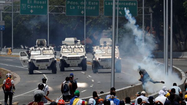 Opposition demonstrators face military vehicles near the Generalisimo Francisco de Miranda Airbase La Carlota in Caracas - Sputnik International