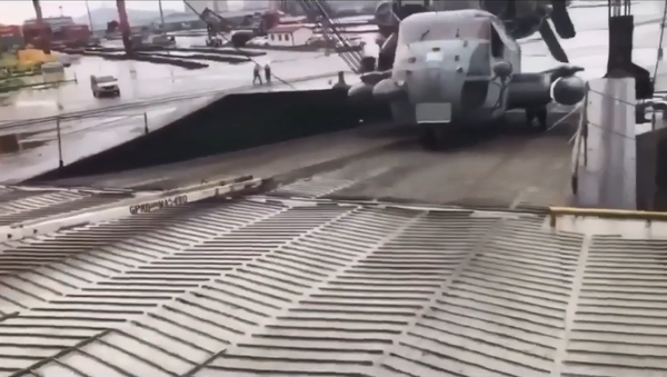 A US Marine Corps CH-53E Super Stallion comes loose from its tow bar and rolls backwards down the gangway - Sputnik International