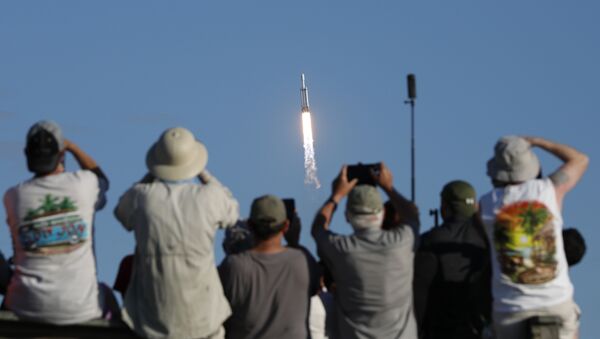 Visitors at Playalinda Beach look on as a SpaceX Falcon Heavy rocket launches from Pad 39B at the Kennedy Space Center in Florida, on April 11, 2019 - Sputnik International