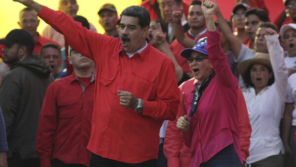 Venezuela's President Nicolas Maduro, center left, and his wife Cilia Flores, center right, wave at supporters during a rally in Caracas, Venezuela, Wednesday, May 1, 2019. Opposition leader Juan Guaidó called for Venezuelans to fill streets around the country Wednesday to demand President Nicolás Maduro's ouster. Maduro is also calling for his supporters to rally. - Sputnik International