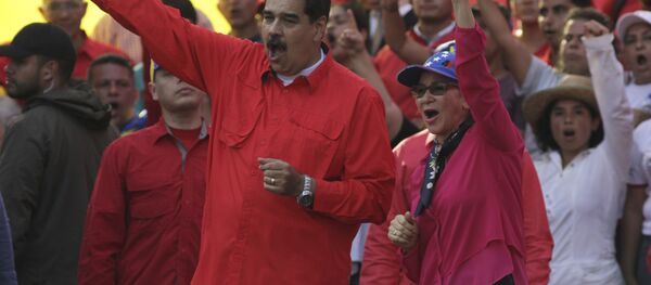 Venezuela's President Nicolas Maduro, center left, and his wife Cilia Flores, center right, wave at supporters during a rally in Caracas, Venezuela, Wednesday, May 1, 2019. Opposition leader Juan Guaidó called for Venezuelans to fill streets around the country Wednesday to demand President Nicolás Maduro's ouster. Maduro is also calling for his supporters to rally. - Sputnik International