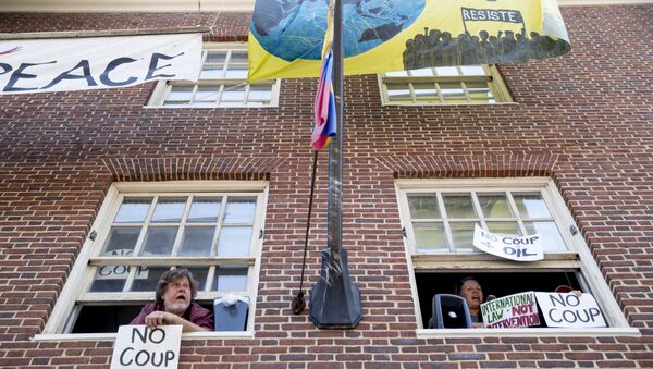 Pro Nicolas Maduro supporters look out the windows of the Venezuelan Embassy in Washington, Thursday, May 2, 2019. Pro interim government opposition leader Juan Guaido supporters have blocked the entrances to the embassy, cutting off supplies to pro Nicolas Maduro supporters occupying the building. - Sputnik International