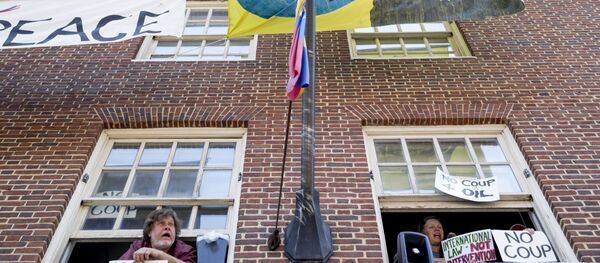 Pro Nicolas Maduro supporters look out the windows of the Venezuelan Embassy in Washington, Thursday, May 2, 2019. Pro interim government opposition leader Juan Guaido supporters have blocked the entrances to the embassy, cutting off supplies to pro Nicolas Maduro supporters occupying the building. - Sputnik International