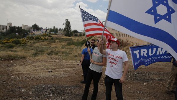 sraelis hold American and Israeli flags with the new U.S. embassy in the background in Jerusalem, Monday, May 14, 2018 - Sputnik International