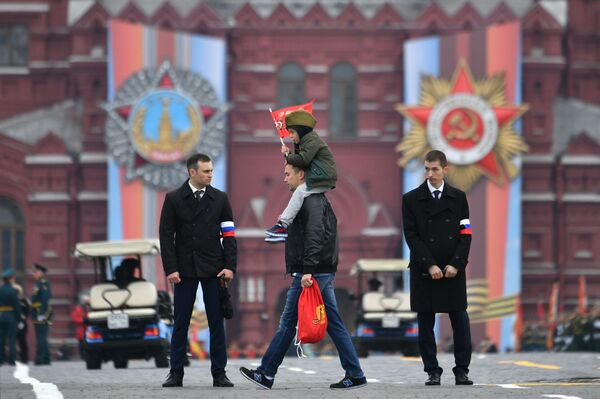 A Man Carrying a Child Before the Victory Day Parade at the Red Square in Moscow - Sputnik International