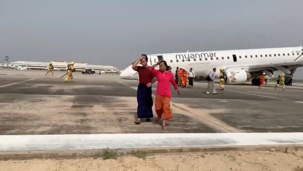 Passengers walk away from the plane after Myanmar National Airlines flight UB103 landed without a front wheel at Mandalay International Airport in Tada-u - Sputnik International