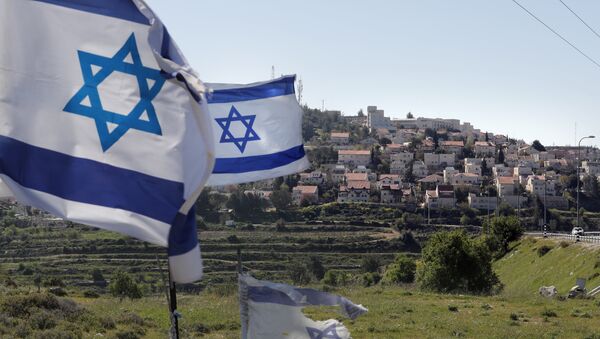 A photo taken on April 12, 2019 shows Israeli flags in front of a partial view of the Israeli settlement of Efrat situated on the southern outskirts of the West Bank city of Bethlehem - Sputnik International