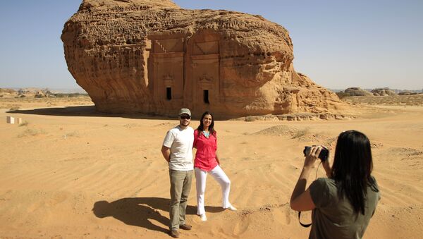 In this photograph made on Thursday, May 10, 2012, a foreign tourist takes picture of couple in the desert archaeological site of Madain Saleh, in Al Ula city, 1043 km (648 miles) northwest of the capital Riyadh, Saudi Arabia - Sputnik International