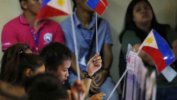 Volunteers of an election watchdog wave Philippine flags to seek assistance during the unofficial tally of votes at Monday's midterm elections Tuesday - Sputnik International