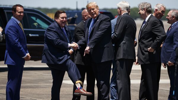President Donald Trump looks the socks of Lt. Gov. Billy Nungesser, R-La., after arriving at Chennault International Airport, Tuesday, May 14, 2019, in Lake Charles, La. - Sputnik International