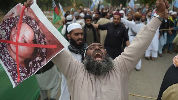 In this file photo taken on November 2, 2018 a Pakistani supporter of the Ahle Sunnat Wal Jamaat (ASWJ), a hardline religious party, holds an image of Christian woman Asia Bibi during a protest rally following the Supreme Court's decision to acquit Bibi of blasphemy, in Islamabad - Sputnik International