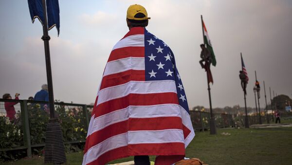 An Indian worker wears an American flag before it is hoisted up a flag pole in New Delhi, India, Friday, Jan. 23, 2015 - Sputnik International