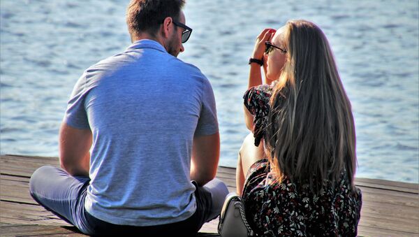 Couple talking while sitting on a dock - Sputnik International