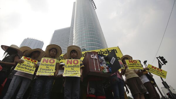 FILE - In this May 7, 2015, file photo, Filipino environmental activists hold slogans about the 50 containers of waste that were shipped from Canada to the Philippines two years ago, during a protest outside the Canadian embassy at the financial district of Makati, south of Manila, Philippines - Sputnik International