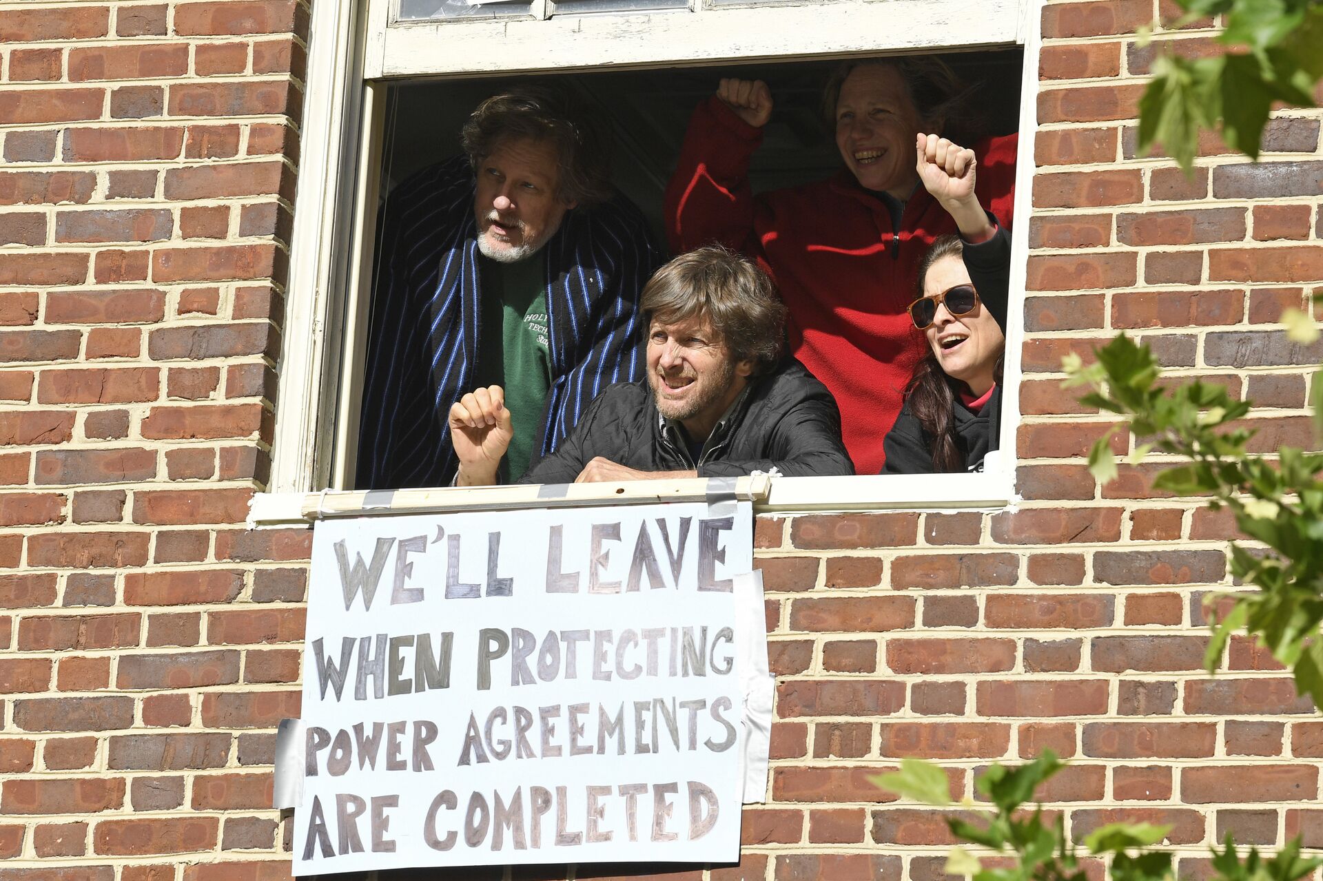 The four activists inside the Venezuelan embassy in Washington look outside the window from a second floor on Tuesday, May 14, 2019. Clockwise from left: Kevin Zeese, Margaret Flowers, Adrienne Pine, and David Paul. - Sputnik International, 1920, 06.01.2023