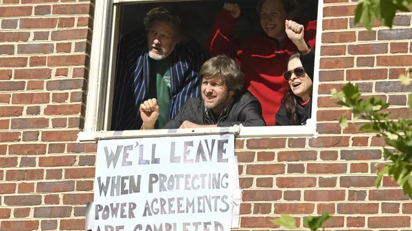 The four activists inside the Venezuelan embassy in Washington look outside the window from a second floor on Tuesday, May 14, 2019. Clockwise from left: Kevin Zeese, Margaret Flowers, Adrienne Pine, and David Paul. - Sputnik International