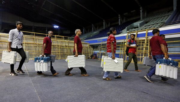FILE PHOTO: Members of election staff carry Electronic Voting Machines (EVM) and Voter Verifiable Paper Audit Trail (VVPAT) machines after collecting them from a distribution centre at an indoor stadium ahead of the seventh and last phase of general election, in Kolkata, India, May 18, 2019. - Sputnik International
