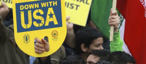 A demonstrator holds an anti-U.S. placard during a ceremony celebrating the 40th anniversary of the Islamic Revolution, at the Azadi, Freedom, Square in Tehran, Iran, Monday, Feb. 11, 2019 - Sputnik International