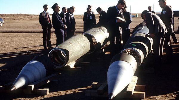 Soviet inspectors and their American escorts stand among several dismantled Pershing II missiles as they view the destruction of other missile components - Sputnik International