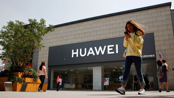  A woman looks at her phone as she walks past a Huawei shop in Beijing, China May 16, 2019 - Sputnik International