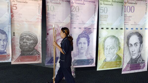 A woman walks past banners portraying the Venezuelan currency, the Bolivar, at the Venezuelan Central Bank in Caracas  - Sputnik International