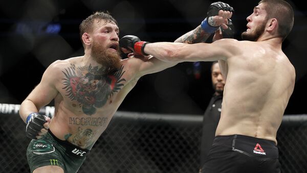 Conor McGregor, left, and Khabib Nurmagomedov throw punches during a lightweight title mixed martial arts bout at UFC 229 in Las Vegas, Saturday, Oct. 6, 2018 - Sputnik International