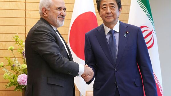 Iranian Foreign Minister Mohammad Javad Zarif, left, and Japanese Prime Minister Shinzo Abe, right, shake hands at Abe's official residence in Tokyo Thursday, May 16, 2019 - Sputnik International
