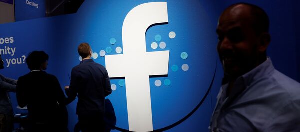 Attendees walk past a Facebook logo during Facebook Inc's F8 developers conference in San Jose, California, U.S., April 30, 2019 - Sputnik International
