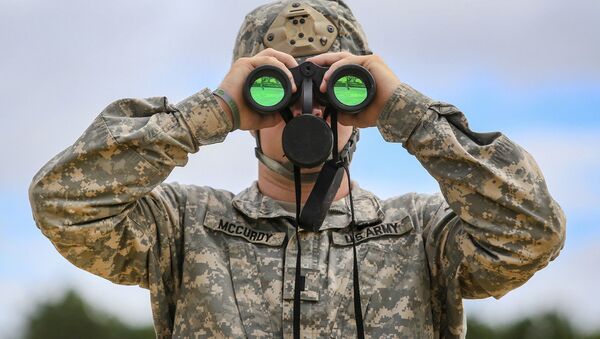 Army 1st Lt. James McCurdy uses binoculars to observe targets down range while his soldiers fire MK 19 grenade launchers during training at Joint Base McGuire-Dix-Lakehurst, N.J., July 26, 2018 - Sputnik International