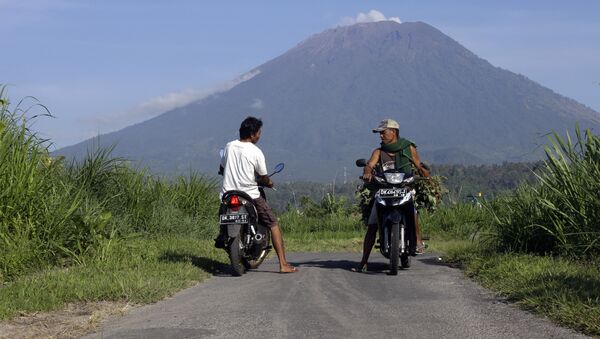 Villagers on their motorcycles talk each other with Mount Agung volcano in the background in Karangasem, Bali, Indonesia, Wednesday, Oct. 25, 2017 - Sputnik International