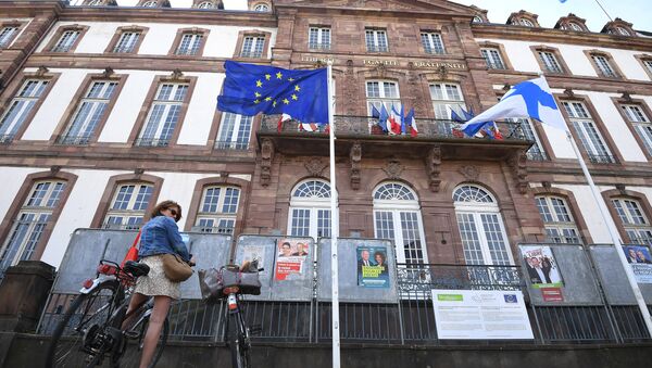 This picture taken on May 26, 2019 shows a woman on a bicycle standing in front of a European flag during the European Parliament elections at a polling station in Strasbourg, eastern France. - Sputnik International