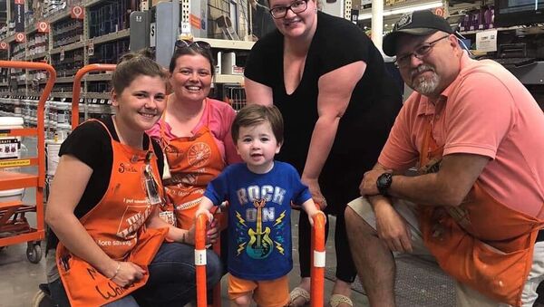 Toddler and his family pose with Home Depot workers who donated and assembled the two-year-old's PVC walker - Sputnik International