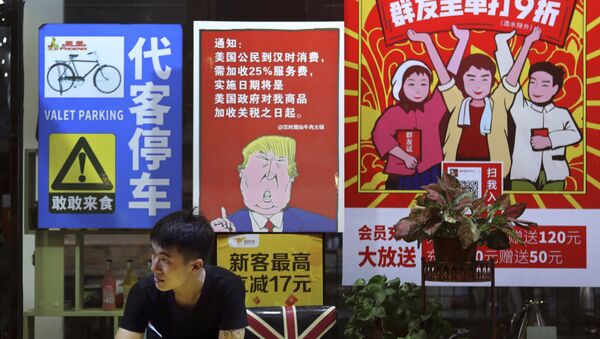 A man stands near a poster depicting a mural of U.S. President Donald Trump stating that all American costumers will be charged 25 percent more than others starting from the day president Trump started the trade war against China, on display outside a restaurant in Guangzhou in south China's Guangdong province.  - Sputnik International
