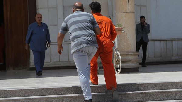 In this Sunday, May 5, 2019 photo, an IS suspect wearing a red prison suit, center right, being led to the Iraqi Criminal Court in Baghdad's Karkh district, Iraq - Sputnik International