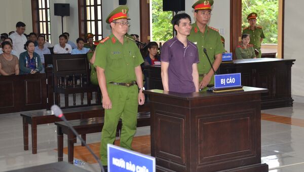 Vietnamese Facebook user Nguyen Ngoc Anh stands between policemen during his trial at a court in Ben Tre province - Sputnik International